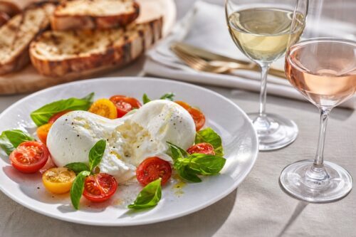 Burrata avec tomates, basilic, pain grillé, un verre de vin blanc et un verre de rosé, sans texte ni personne