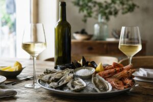 Plateau de fruits de mer avec deux verres de vin blanc et une bouteille sans étiquette