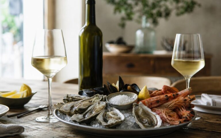 Plateau de fruits de mer avec deux verres de vin blanc et une bouteille sans étiquette