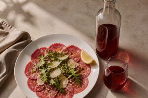 Carpaccio de bœuf au parmesan avec un verre de vin rouge léger